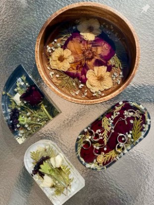 Pressed flowers arranged in a wooden bowl and resin trays before preservation